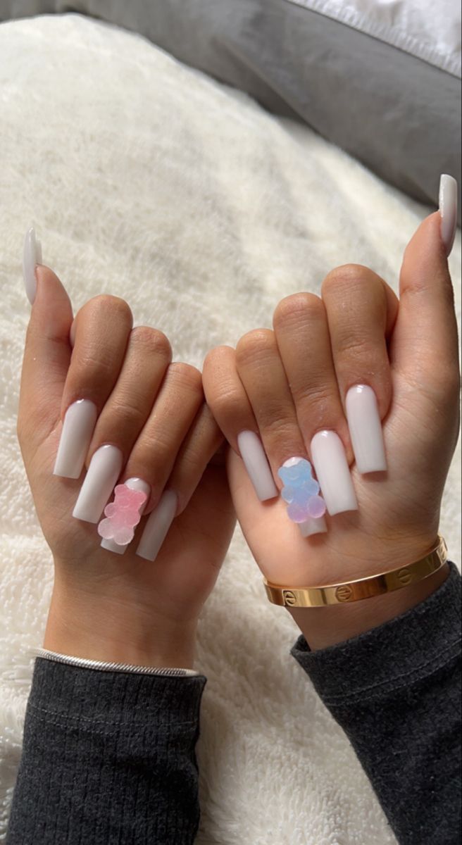 Sophisticated Long White Nails with Pastel Flower Accents and Chic Bracelet.