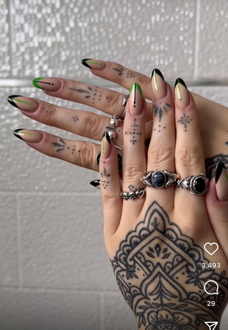 Bold Artistic Expression: Elegant Nail Design with Black Tips and Vibrant Green Accents Enhanced by Intricate Hand Tattoos.