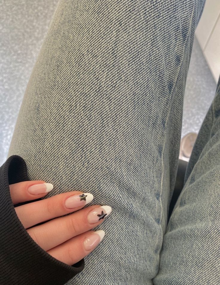 Chic French Manicure with Whimsical Star Accents on Denim Texture.