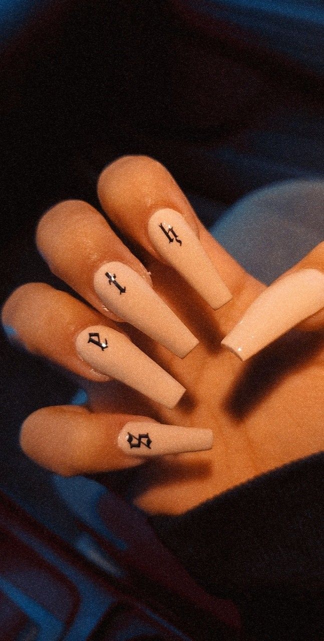 Elegant Nude Acrylic Nails with Bold Black Symbols for a Striking Statement.