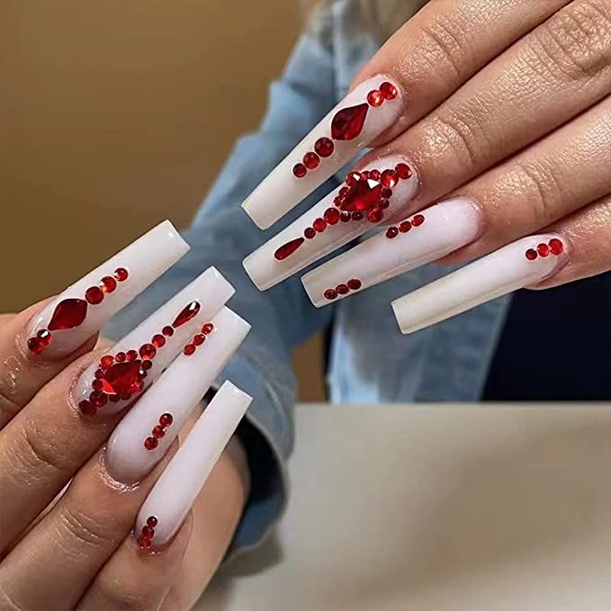 Glamorous Long White Coffin Nails Adorned with Red Gemstones for a Bold Fashion Statement.