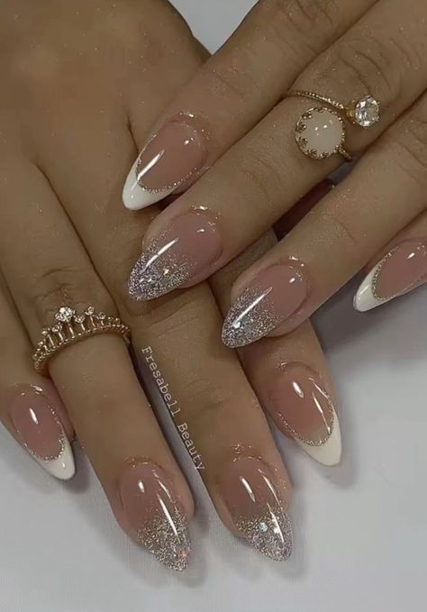 Sophisticated Nail Design with Soft Pink and White Tips Accented by Glitter and Delicate Rings.