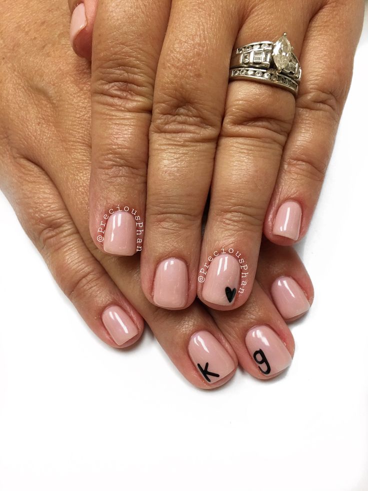 Elegant Nude Nail Design with Personalized Black Lettering and Subtle Heart Detail.