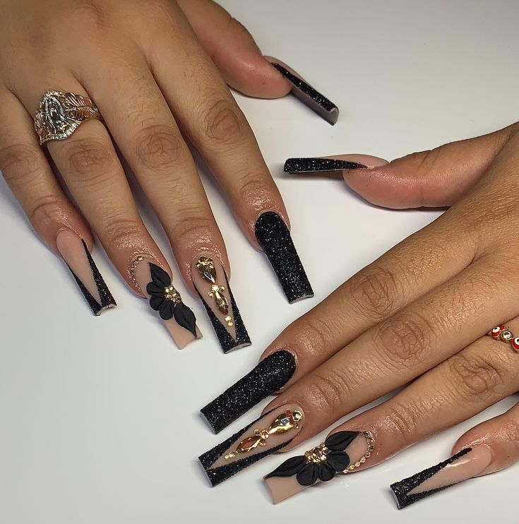 Sophisticated Nail Design with Sharp Tips, Black-and-Nude Palette, and Embellishments.