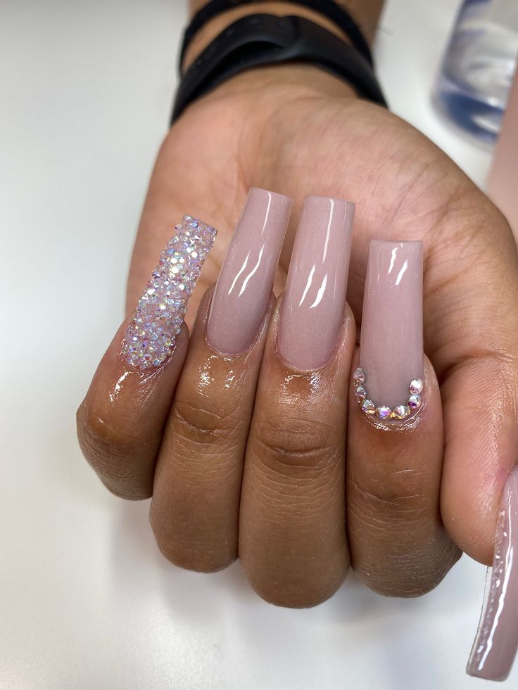 Sophisticated Nude Nail Design with Rhinestone Accent and Glossy Finish.