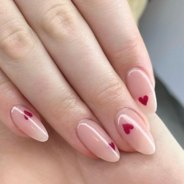 Charming Romantic Nail Art: Delicate Nude Base with Playful Red Heart Accents