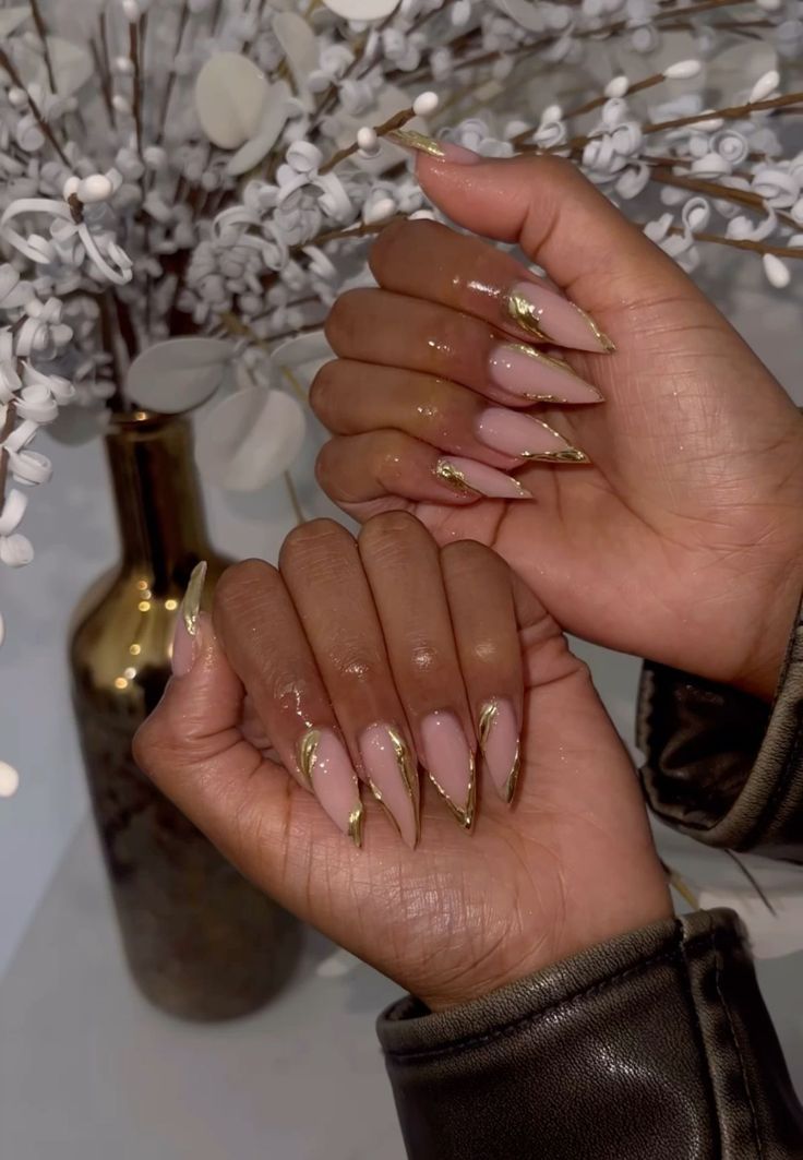 Chic Stiletto Nails with Nude Base and Glamorous Gold Tips for Sophisticated Style.