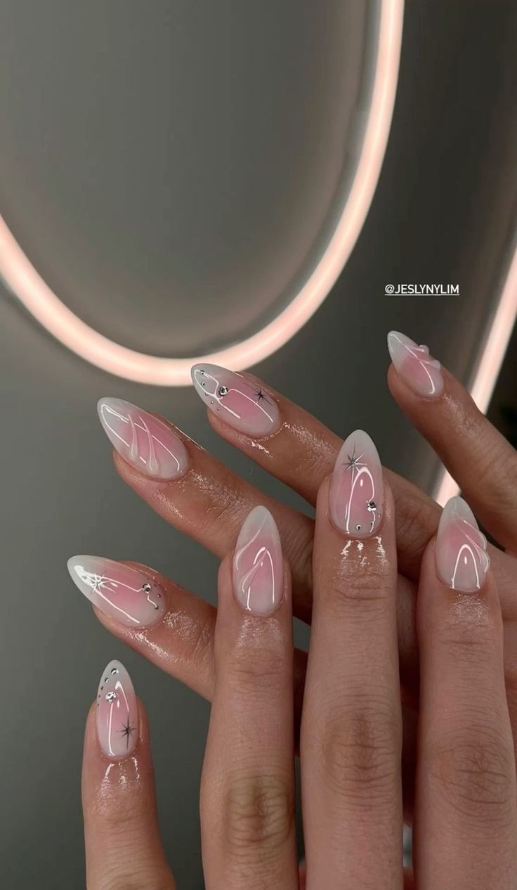 Chic Almond-Shaped Nail Design with Soft Pink Base and Elegant Floral Accents.