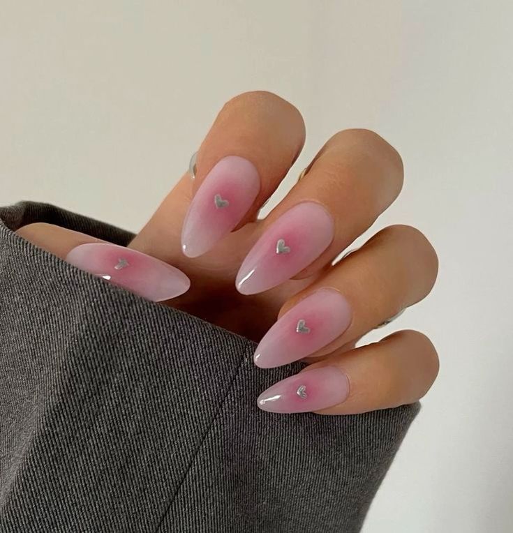 Elegant Ombre Pink Nails with Heart Embellishments and Almond Tips for a Romantic Look.