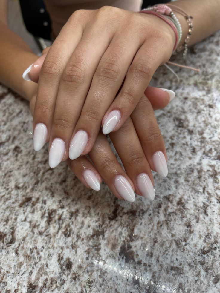 Sophisticated Almond-Shaped Ombre Nails with Sheer Pink Base and Glossy White Tips.