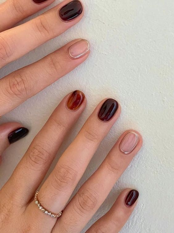 Sophisticated Burgundy and Black Nail Design with Striking Translucent Accent.