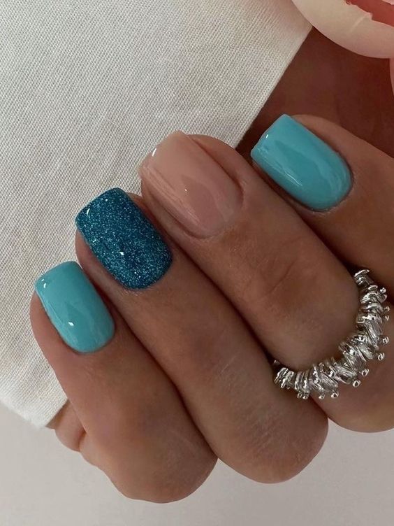 Playful Turquoise Nail Design with Glittery Accents and Contrasting Glossy Blue and Soft Nude.