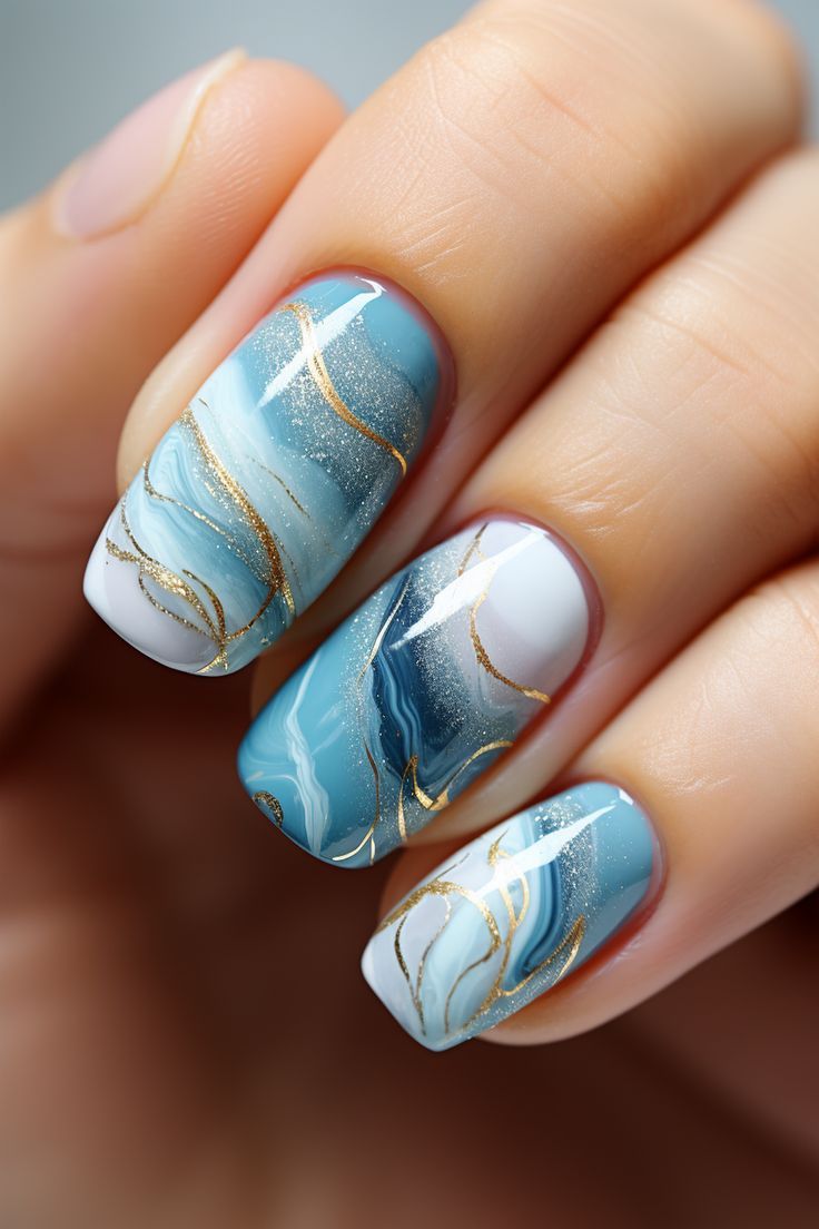 Elegant Blue and White Marble Swirl Nail Design with Gold Accents.