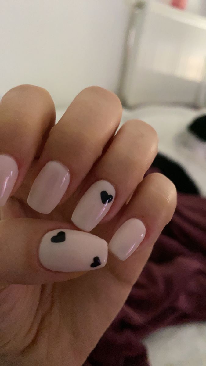 Trendy Pastel Pink Nail Design with Playful Black Heart Accents.