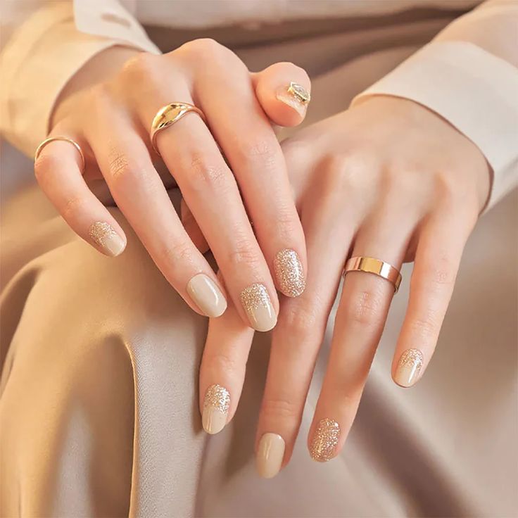 Elegant Neutral Nail Design with Glossy Finish and Shimmering Gold Accents.