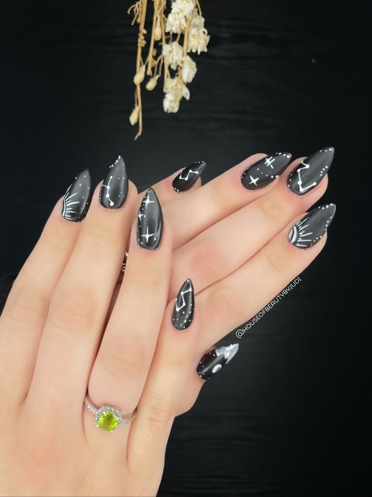 Sophisticated Celestial-Inspired Black and Silver Almond-Shaped Nail Design.