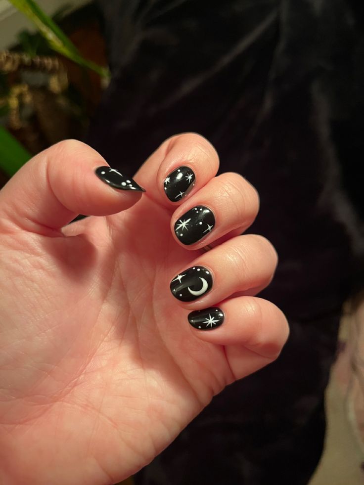 Celestial-Inspired Nail Art: Elegant Black Base with Starry White Accents.