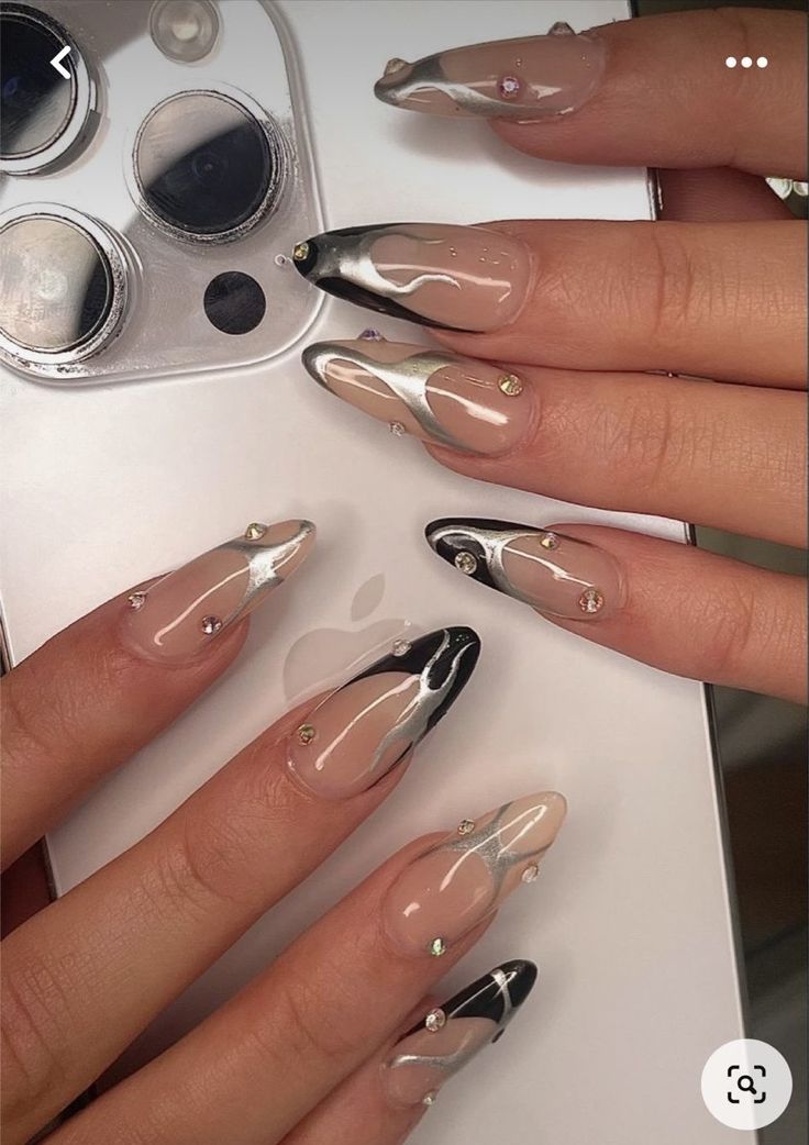 Chic Modern Nail Design with Glossy Black and White Swirls and Sparkling Gems