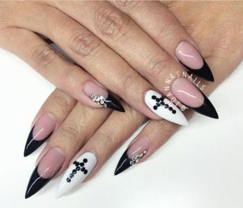 Elegant Stiletto Nail Design: Striking Glossy Black and White with Crystal Accents.