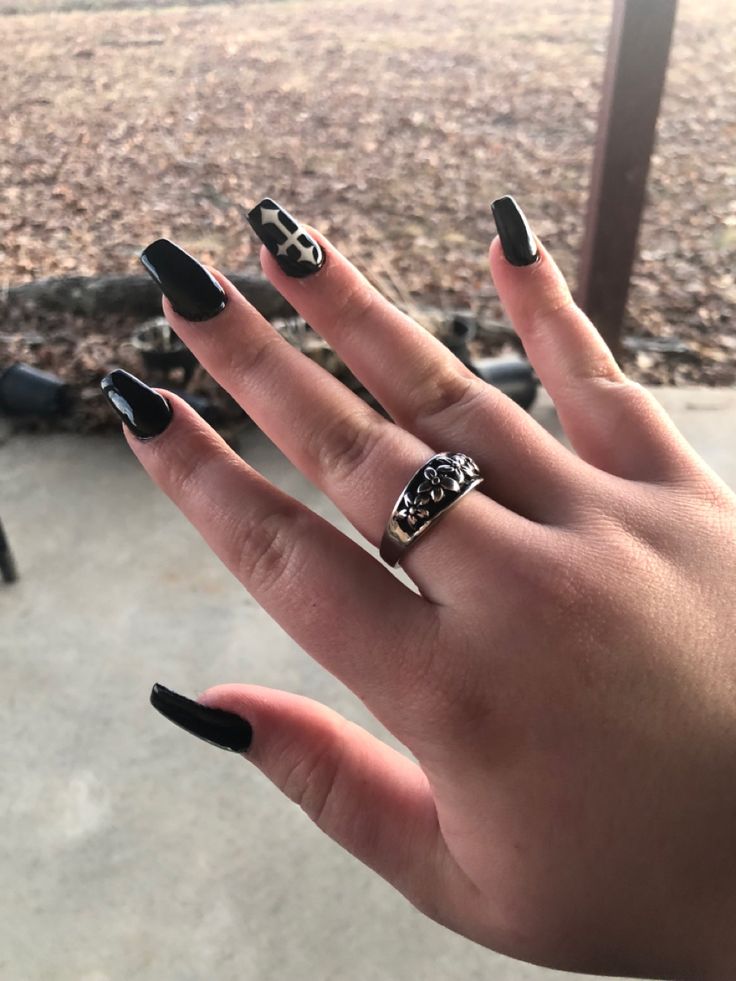 Sophisticated Glossy Black Nails with Unique Accents and Bold Patterns.