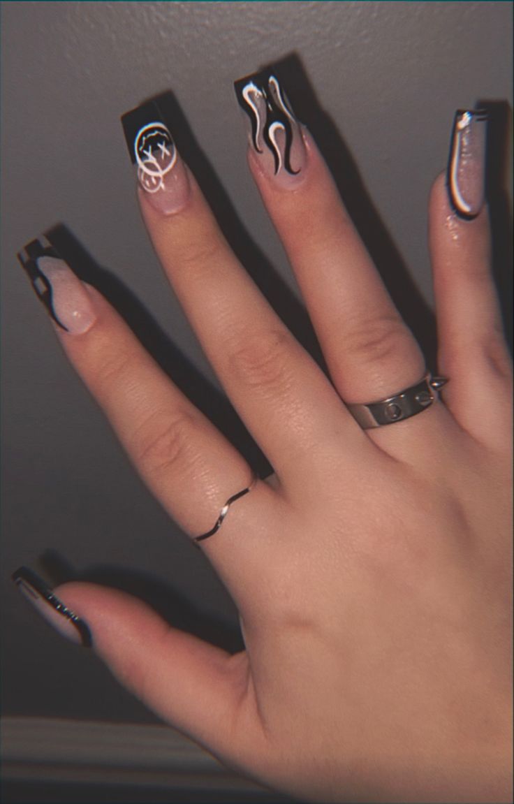 Trendy Elongated Black French Tip Nail Design with Artistic Flames and Graphic Accents.