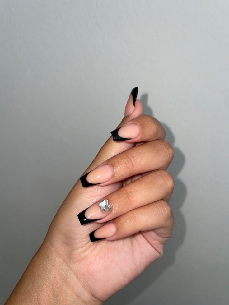 Chic French Tip Manicure with Nude Base and Striking Black Tips Enhanced by Subtle Silver Accents.