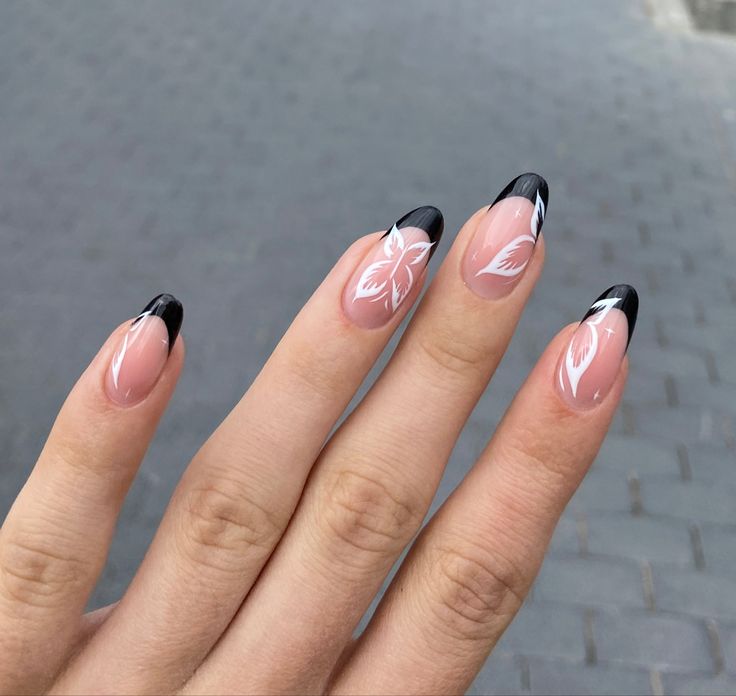 Elegant Nude and Black Tip Nail Design with Delicate Floral Patterns