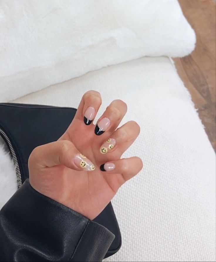 Chic Black-Tipped Nude Nails: A Whimsical Touch with Smile Face Decals.