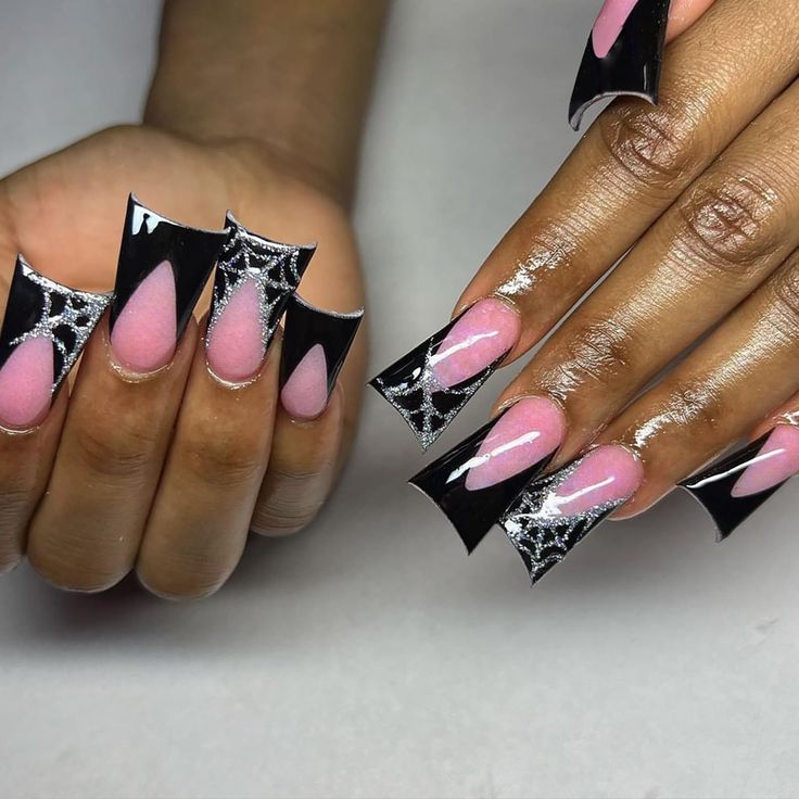 Bold Nail Design: Sharp Black Tips and Subtle Pink Base with Intricate Shimmering Spider Web Patterns.