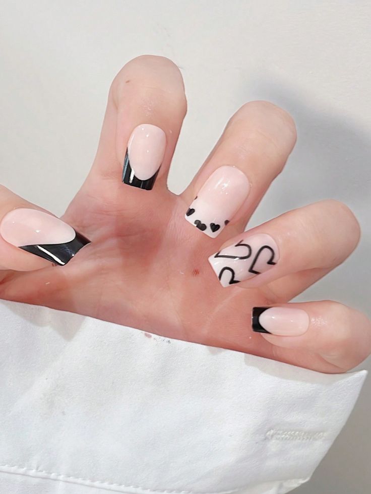 Elegant Chic Nail Design: Soft Nude Base with Bold Black Accents.