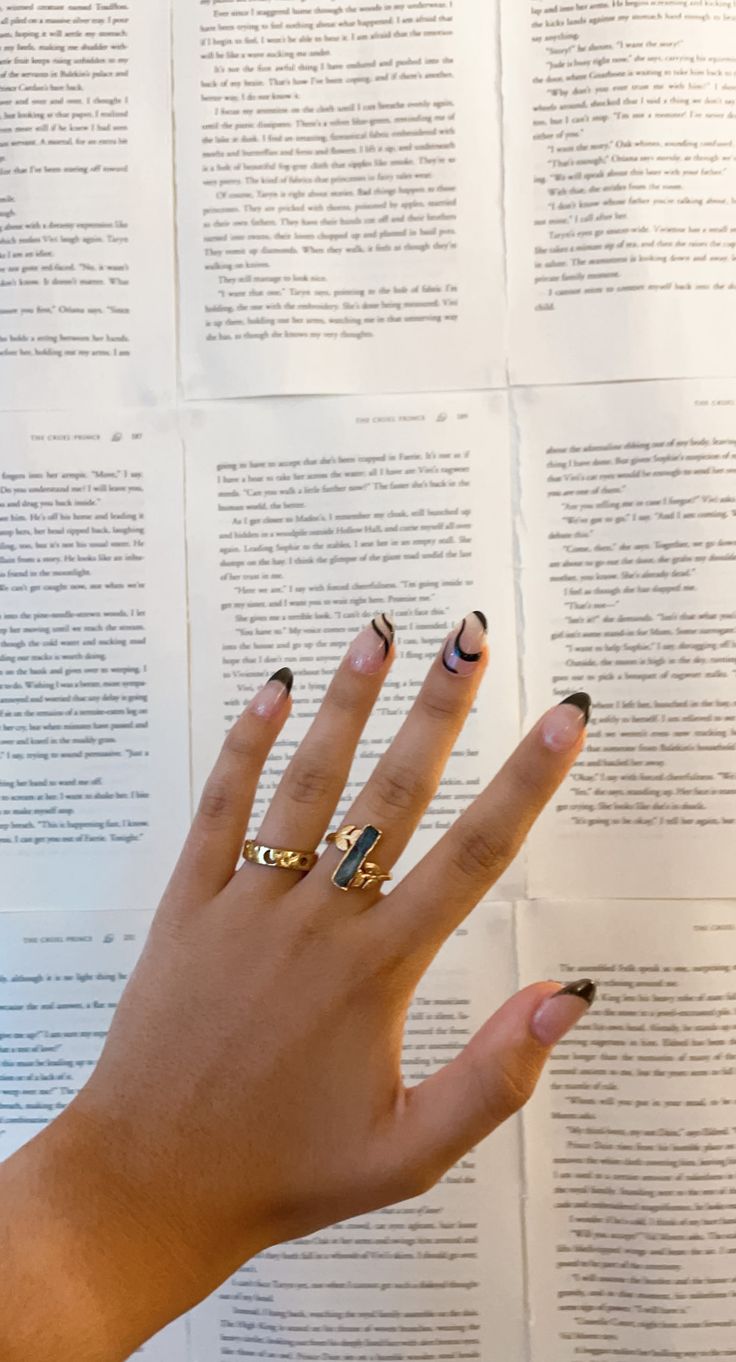 Chic Neutral Nail Design with Black Swirls and Elegant Ring Accents.