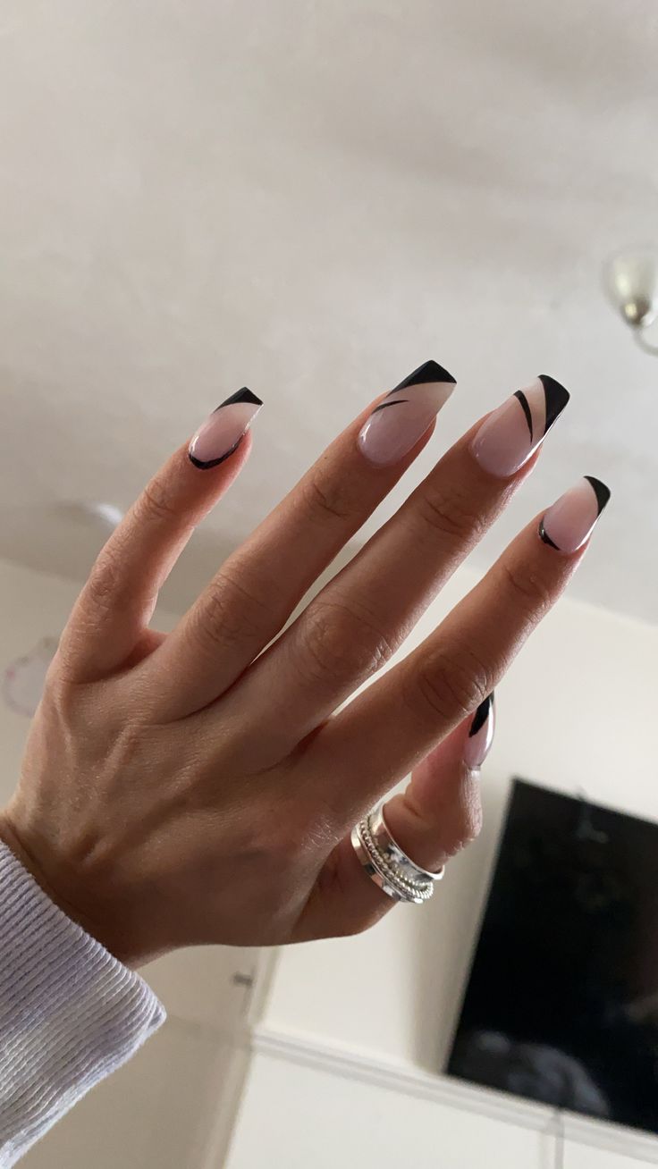 Chic Gradient Nail Design: Soft Pink Base with Striking Black Tips and Modern Accents.