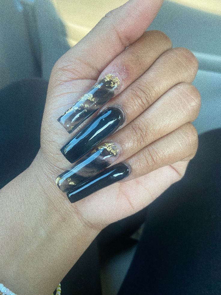 Elegant Black and Clear Acrylic Nail Design with Luxurious Gold Accents.