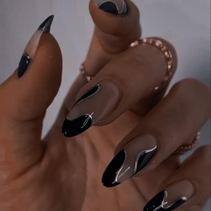 Chic Almond-Shaped Nail Design in Black and Nude with Artistic Wavy Patterns.