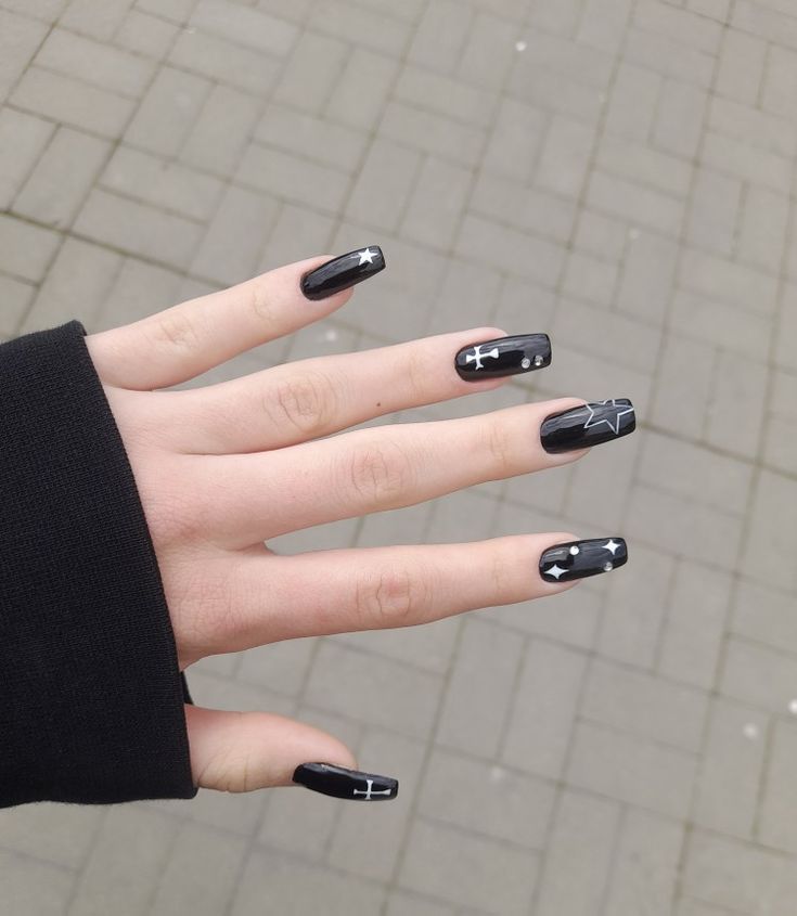 Bold Black Nail Design with Intricate White Detailing and Unique Elements