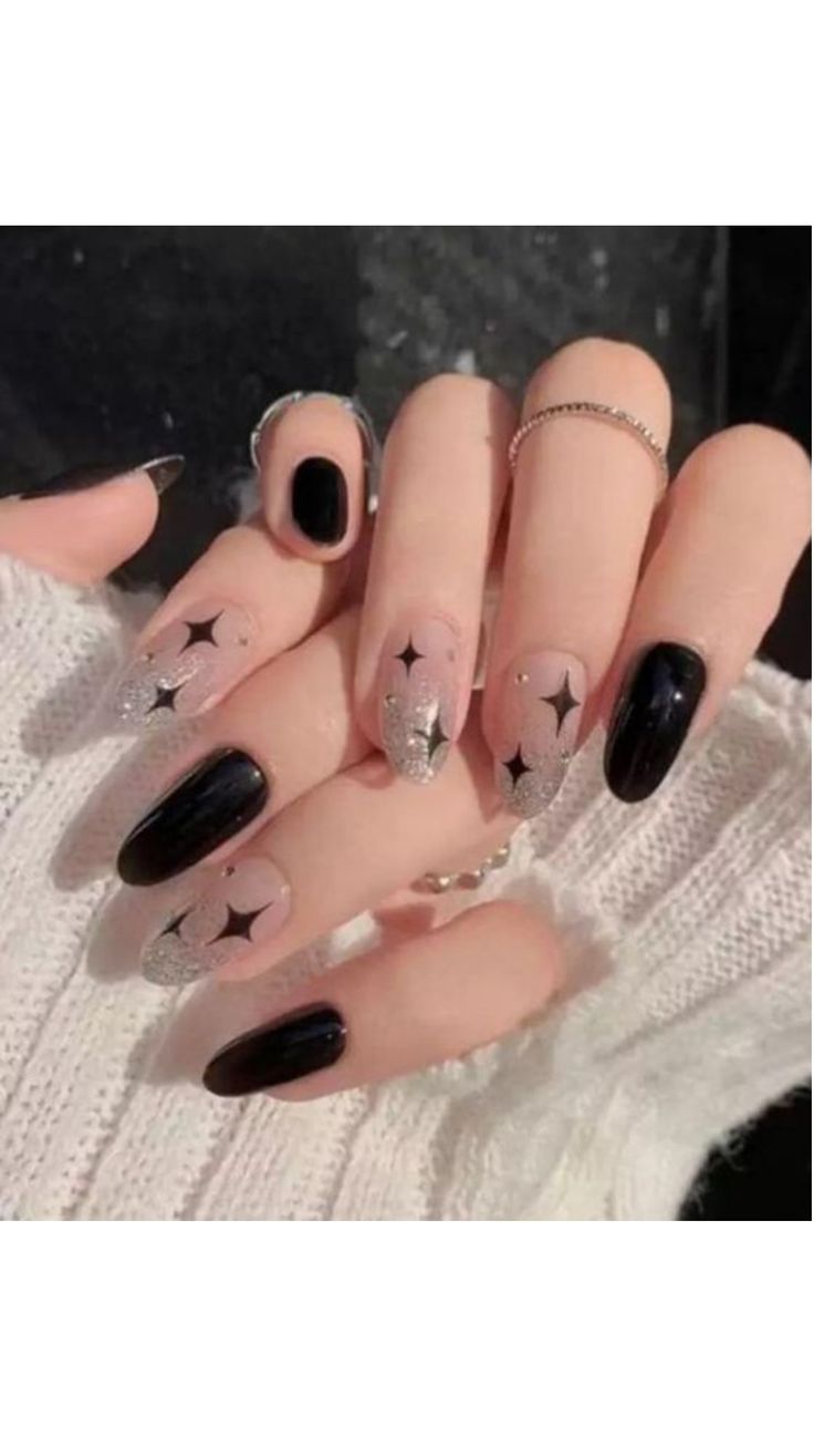 Chic Black and Nude Nail Design with Whimsical Silver Glitter Stars.