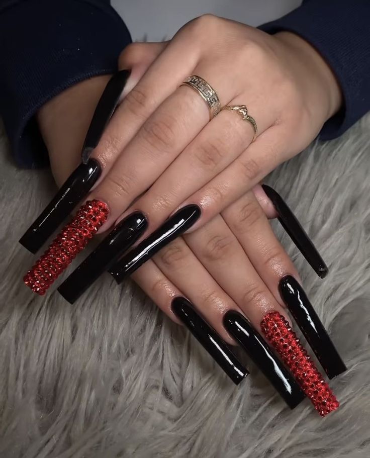 Glamorous Long Nails with Black Polish and Bold Red Rhinestones