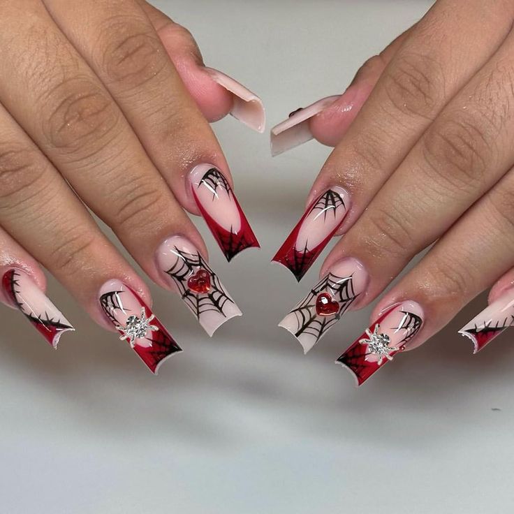 Elegant Halloween Nail Design with Intricate Spider Webs and Bold Red Accents.