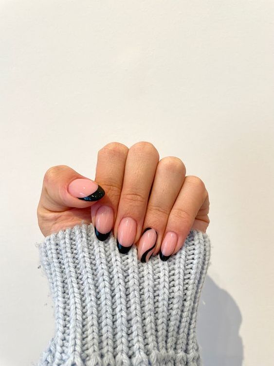 Elegant Chic Nail Design: Soft Nude Base with Bold Black Tips and Sparkly Accent.