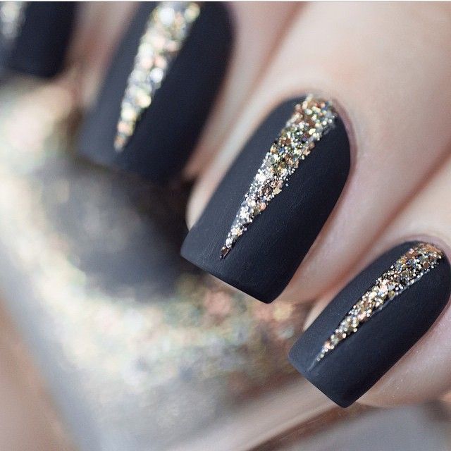 Elegant Matte Black Nails with Striking Gold Accents and Chic Glitter Accents.