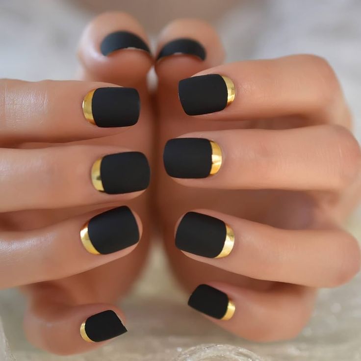 Sophisticated Matte Black Nails with Striking Gold Accents for a Glamorous Touch.