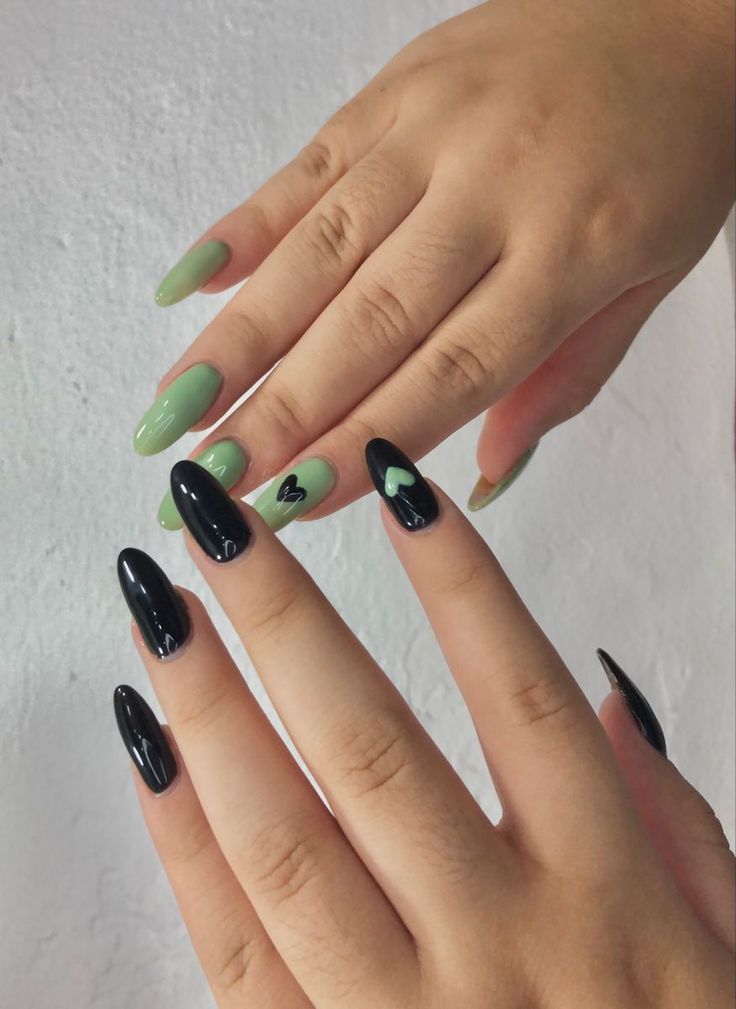 Chic Black and Mint Green Nail Design with Playful Heart Accent.