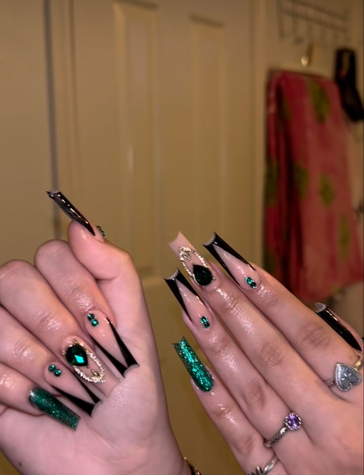 Elegant Emerald Green and Black Nail Art with Gem Embellishments and Glitter Accents