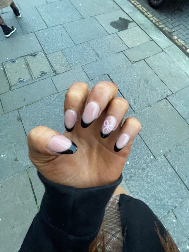 Chic Nude Manicure with Black Tips and Elegant White Artwork