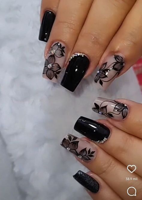 Sophisticated Nail Design with Glossy Black and Translucent Floral Patterns Accented by Gems and Pearls.