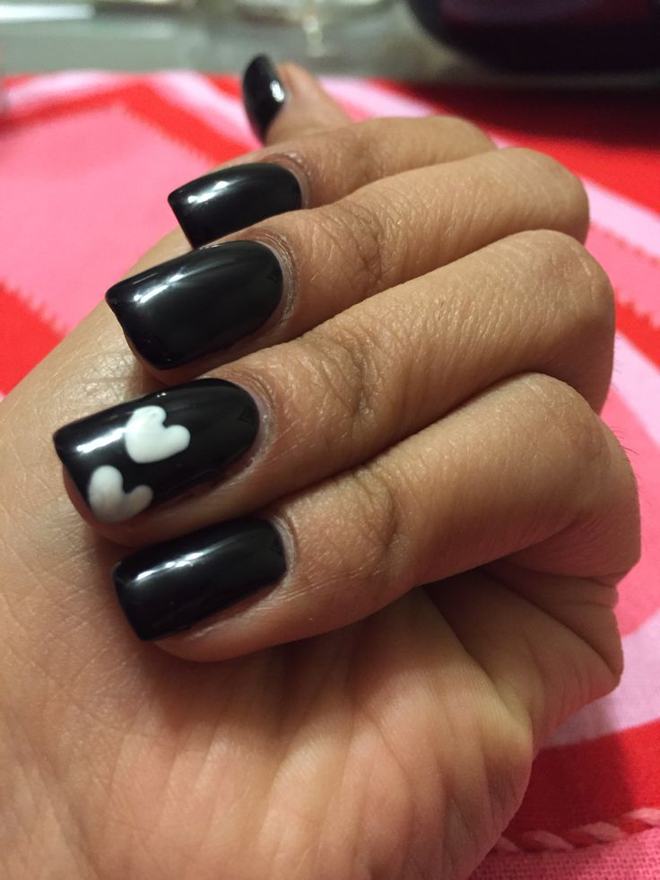 Chic Black Nail Design with Glossy Finish and Playful White Heart Accents.