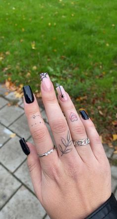 Playful Elegant Nail Design: Glossy Black and Nude with Floral and Heart Details