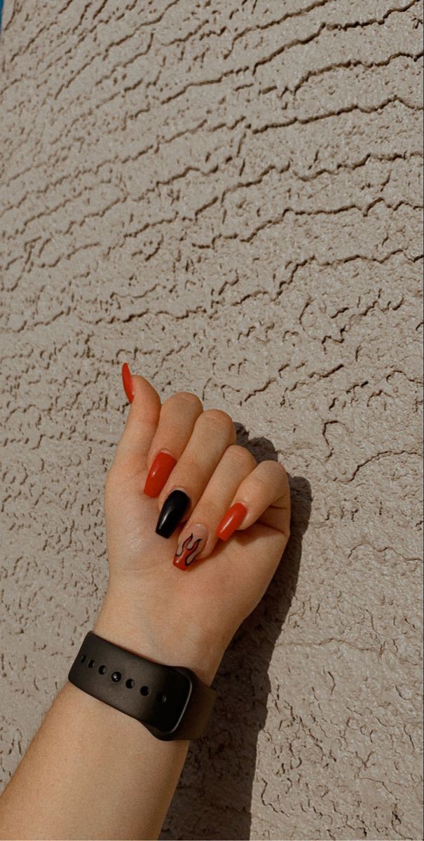 Bold Red and Black Nail Design with Playful Flame Accent for a Modern Statement.