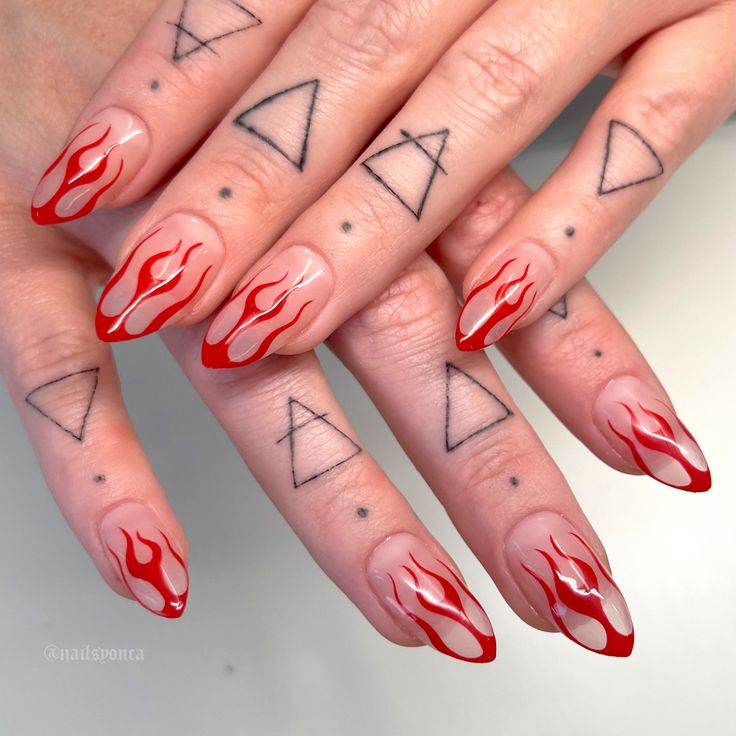 Bold Fiery Stiletto Nail Design with Vibrant Flames and Edgy Geometric Tattoos.