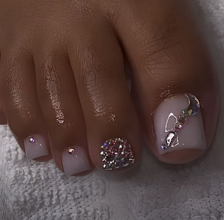 Elegant Chic Pedicure: Soft Nude Polish with Holographic Accents and Gemstone Embellishments for Glamorous Occasions